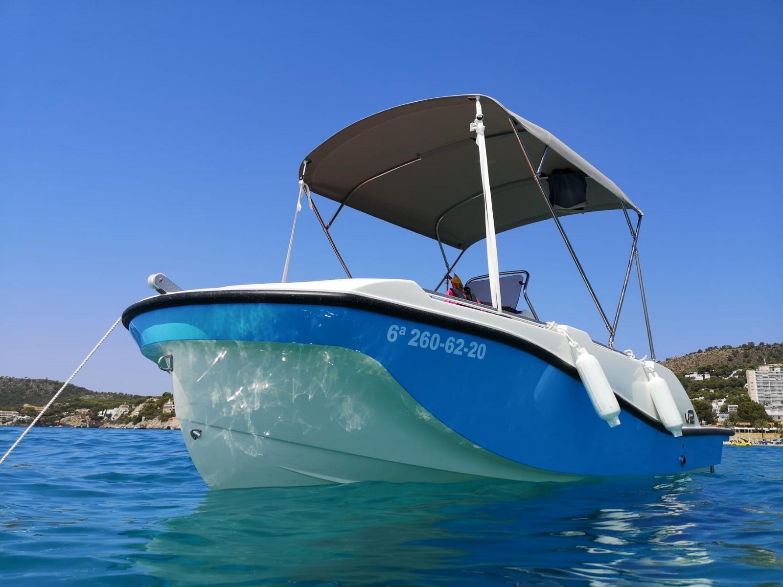 Barco compacto sin licencia color azul fondeado en cala de Mallorca